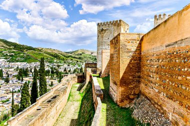 Granada, İspanya; 5 Nisan 2024: Granada 'da Alhambra' nın Alcazaba 'nın kuleleri ve duvarı, Albaicin ve Sacromonte manzaralı