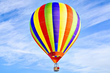 Mavi gökyüzünde beyaz bulutlarla uçan renkli sıcak hava balonu
