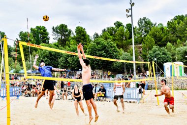 Igualada, Barcelona, İspanya; 13 Temmuz 2024: Şehirde plaj voleybolu oynayan bir grup insan. Spor ve eğlence.