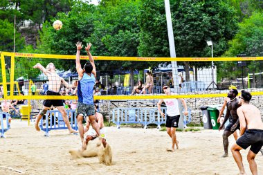 Igualada, Barcelona, İspanya; 13 Temmuz 2024: Şehirde plaj voleybolu oynayan bir grup insan. Spor ve eğlence.