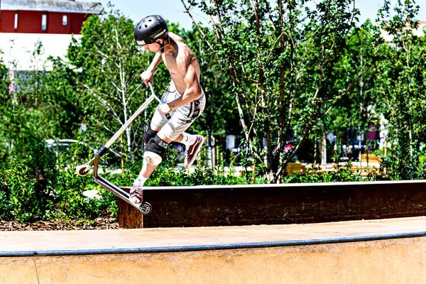 Igualada, Barcelona, İspanya; 25 Haziran 2023: Igualada Central Park 'taki yeni kaykay parkında Scootering (Serbest stil Scootering) uygulayan genç adam