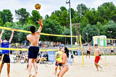 Igualada, Barcelona, İspanya; 13 Temmuz 2024: Şehirde plaj voleybolu oynayan bir grup insan. Spor ve eğlence.