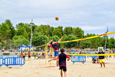 Igualada, Barcelona, İspanya; 13 Temmuz 2024: Şehirde plaj voleybolu oynayan bir grup insan. Spor ve eğlence.