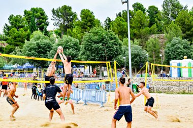 Igualada, Barcelona, İspanya; 13 Temmuz 2024: Şehirde plaj voleybolu oynayan bir grup insan. Spor ve eğlence.