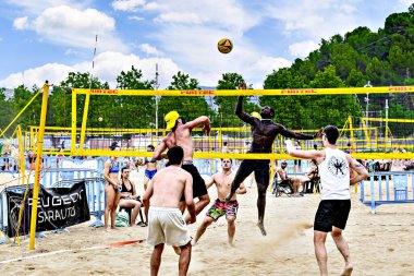 Igualada, Barcelona, İspanya; 13 Temmuz 2024: Şehirde plaj voleybolu oynayan bir grup insan. Spor ve eğlence.