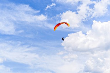 Güneşli bir günde kırmızı ve mavi paraşütle paraşütle atlama macerası.