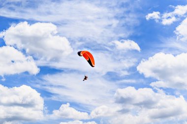 Güneşli bir günde kırmızı ve mavi paraşütle paraşütle atlama macerası.