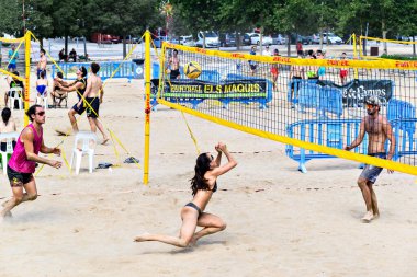 Igualada, Barselona, İspanya, 13 Temmuz 2024: Şehirde plaj voleybolu oynayan bir grup insan. Spor ve eğlence..