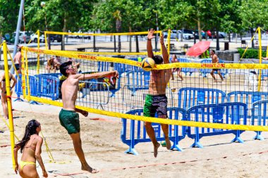 Igualada, Barselona, İspanya, 13 Temmuz 2024: Şehirde plaj voleybolu oynayan bir grup insan. Spor ve eğlence..