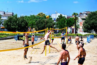 Igualada, Barselona, İspanya, 13 Temmuz 2024: Şehirde plaj voleybolu oynayan bir grup insan. Spor ve eğlence..