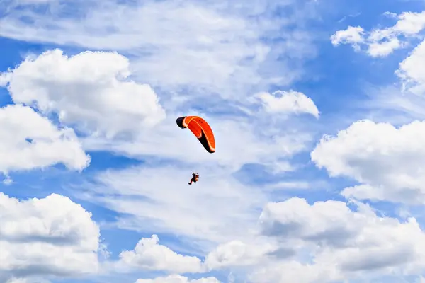 Güneşli bir günde kırmızı ve mavi paraşütle paraşütle atlama macerası.