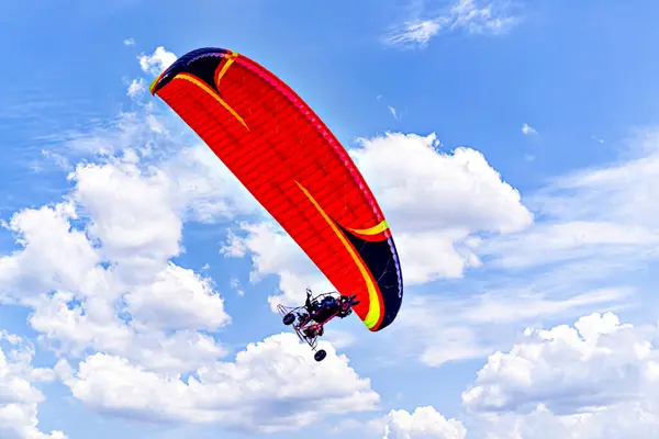 Güneşli bir günde kırmızı ve mavi paraşütle paraşütle atlama macerası.