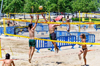 Igualada, Barcelona, İspanya; 13 Temmuz 2024: Şehirde plaj voleybolu oynayan bir grup insan. Spor ve eğlence.
