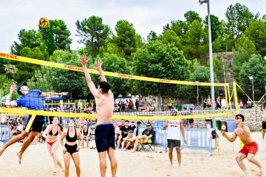 Igualada, Barcelona, İspanya; 13 Temmuz 2024: Şehirde plaj voleybolu oynayan bir grup genç. Spor ve eğlence..
