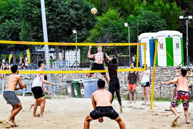 Igualada, Barcelona, İspanya; 13 Temmuz 2024: Şehirde plaj voleybolu oynayan bir grup genç. Spor ve eğlence..