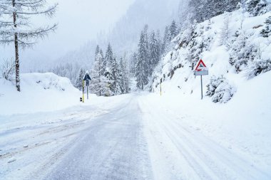 Kışın şiddetli kar yağışında Avrupa Alplerinde karlı bir yol