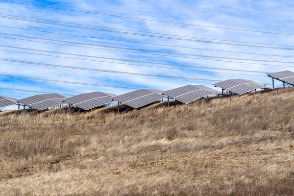 Rows of solar panels for electricity generation on the top of a grassy hill. Napa Valley, CA, USA.