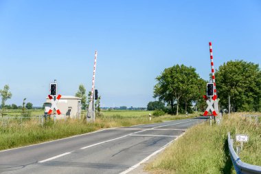 Level crossing with barriers raised in the countryside of Germany on a clear summer day