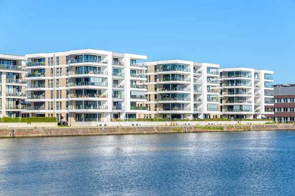New apartment buildings along a river harbour on a clear summer day. Bremerhaven, Germany.