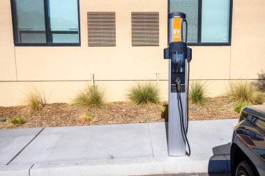 Recharging point for electric vehicles in a parking lot at the back of a building. Santa Clarita, CA, USA.