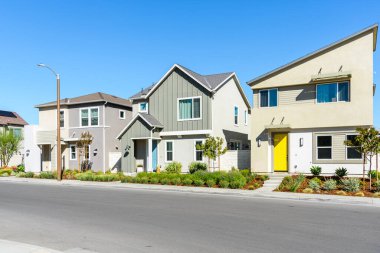 Stylish new detached houses along a street in a housing development on a sunny autumn day. Santa Clarita, CA, USA.