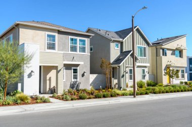 Row of modern detached houses in a housing development in California on a clear autumn day. Santa Clarita, CA, USA.
