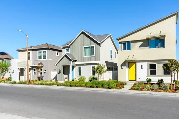 Stylish new detached houses along a street in a housing development on a sunny autumn day. Santa Clarita, CA, USA.