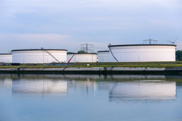 夕暮れ時に石油ターミナルで大規模な原油タンク 水の中の反射 オランダのロッテルダム — ストック写真