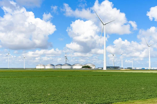 晴れた夏の日に工業団地内の風力タービン 太陽光パネル 燃料貯蔵タンク オランダのエメスハーフェン — ストック写真