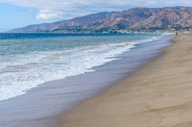 Parçalı bulutlu bir sonbahar gününde Kaliforniya kıyıları boyunca güzel bir sahil. Zuma plajı, Malibu, CA, ABD.