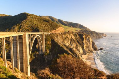 Sonbaharda günbatımında Kaliforniya 'nın kayalık sahillerinde Pasifik kıyısı boyunca Bixby Creek Köprüsü. Big Sur, CA, ABD.
