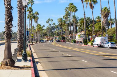 Santa Barbara, CA - 17 Ekim 2022: Güneşli bir sonbahar sabahında palmiye ağaçlarıyla kaplı Batı Cabrillo Bulvarı manzarası. Santa Barbara, Kaliforniya 'da Santa Ynez Dağları ile Pasifik Okyanusu arasında yer alan bir kıyı kentidir..