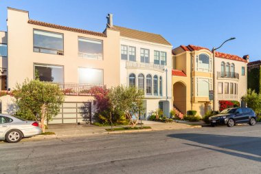 Gün batımında açık gökyüzünün altında bir cadde boyunca uzanan lüks evler. San Francisco, CA, ABD.