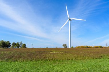 Ruautmn gününde tarlada uzun rüzgar türbini. Diğer rüzgar türbinleri uzaktan görülebilir. Wolfe Adası, On, Kanada.