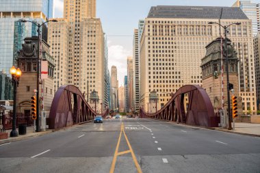 Baharda gün batımında Chicago nehri boyunca uzanan hareketli bir köprü. Illinois, ABD.