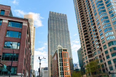 Güneşli bir bahar gününde yüksek binaların ve ofis binalarının alçak açılı görüntüsü. Chicago, IL, ABD.