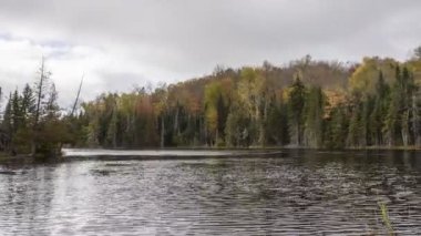 Sonbaharda New York 'taki Adirondack Dağları' nda orman kıyıları olan bir gölün üzerinden geçen bulutlar