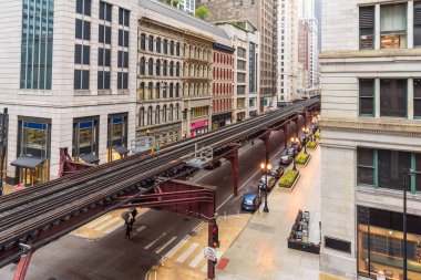 Yağmurlu bir bahar gününde Chicago şehir merkezinde geleneksel mimariyle aynı hizada yükseltilmiş demiryolu rayları. Chicago, IL, ABD.