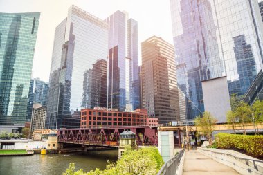 Chicago Donwtown gökyüzü bulutlu bir bahar gününde nehir kenarındaki bir patikadan görüldüğü gibi. Chicago, IL, ABD.