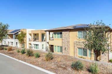 Açık bir sonbahar gününde çatısı güneş panelli yeni enerji tasarruflu yarı müstakil evler. Santa Clarita, CA, ABD.