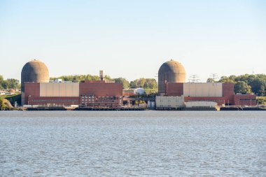 Güneşli bir sonbahar gününde, bir nehrin kenarında nükleer enerji santrali. Hudson Nehri Vadisi, New York, ABD.