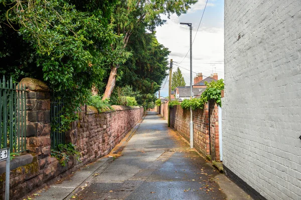 Güneşli bir yaz gününde taş ve tuğla duvarlar arasında uzanan boş dar bir sokak. Chester, İngiltere, İngiltere.