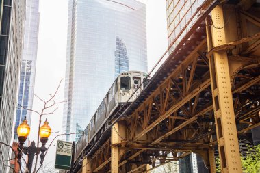 Low angle view of an elevated train transiting Chicago downtown. Chicago Loop,  Illinois, USA. clipart