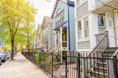İlkbaharda bir yerleşim bölgesinde ağaçlık bir cadde boyunca uzanan geleneksel ağaçlık evler. Chicago, IL, ABD.