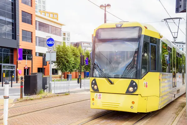 一辆黄色的电车沿着郊区的一条街道行驶 曼彻斯特 — 图库照片