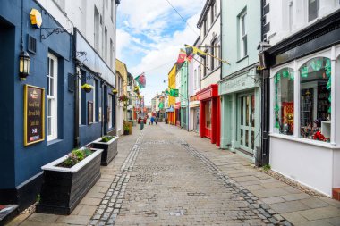 Caernarfon, Galler, İngiltere - 10 Temmuz 2023: Eski kasabadaki Palace Caddesi boyunca yürüyen insanlar. Caernarfon işlek bir limanı ve Menai Boğazı manzarası olan hareketli bir pazar kasabası..