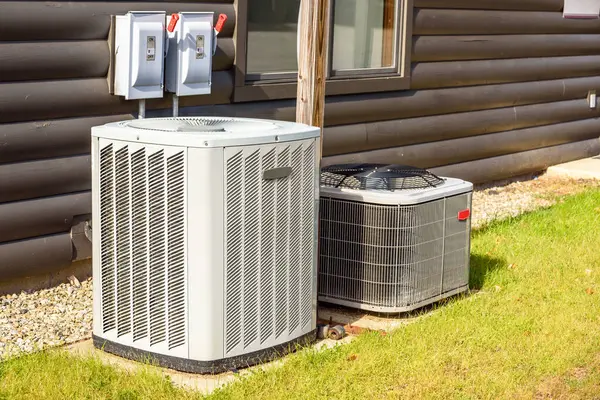 stock image Heating and air conditioning system external units on grass in a house backyard on a sunny day