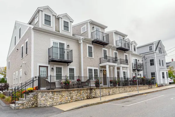 stock image New row houses with a fenced  front garden along a street on a cloudy autumn day. Plymouth, MA, USA.