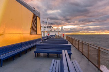 Sonbaharda gün batımında nehir kenarındaki bir petrol terminalinde paslı yakıt tankları. Groton, CT, ABD
