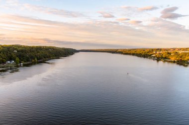 Hudson Nehri 'nin sonbaharda günbatımında orman kayalıklarıyla kaplı muhteşem manzarası. Poughkeepsie, New York, ABD.